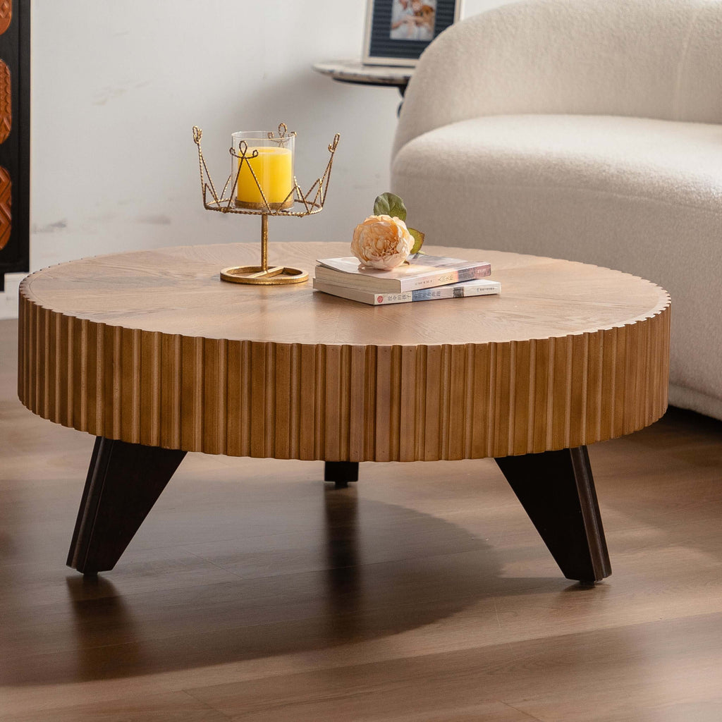 35.4" round retro coffee table in natural oak finish with books and candle on top.
