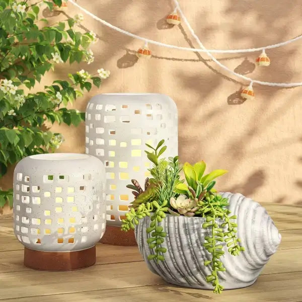 Modern white ceramic candle holder casting warm glow on a mantel