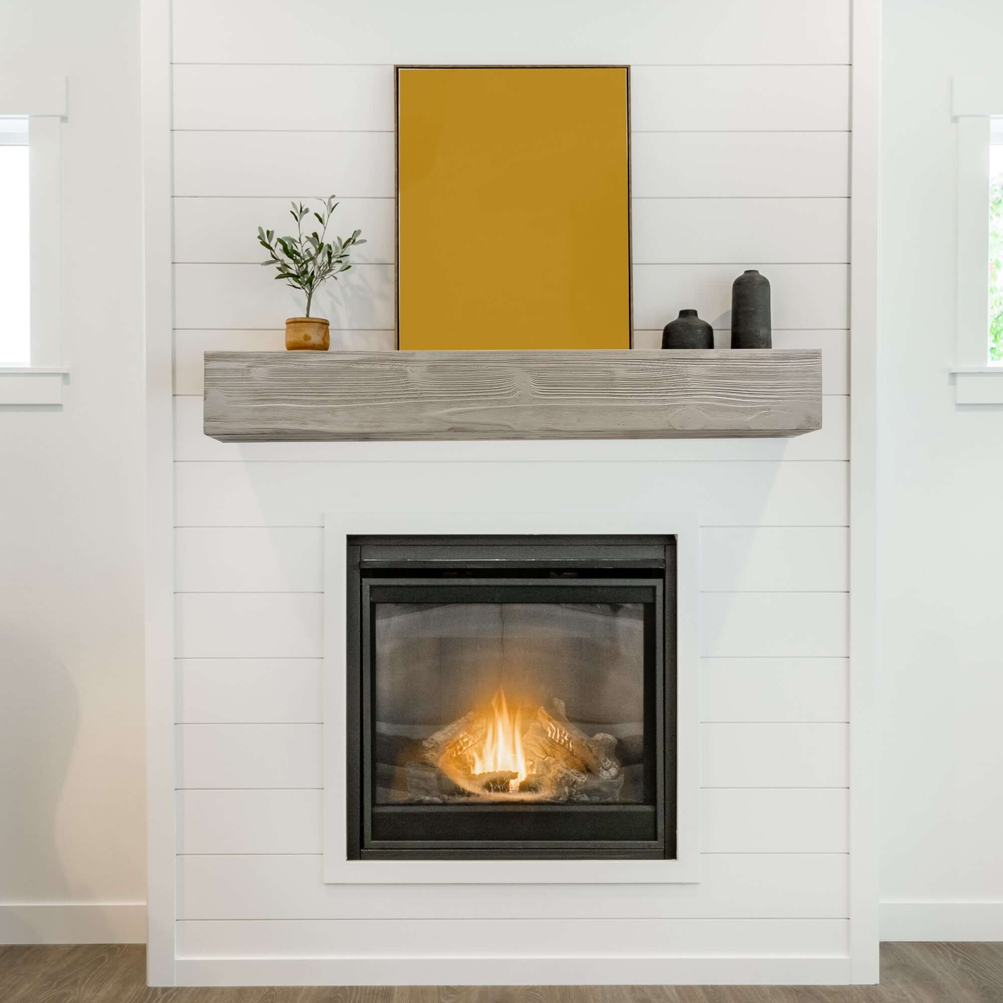 Large farmhouse style wood mantel with candles and flowers