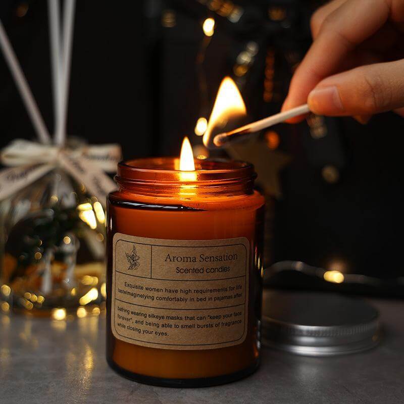 Aromatherapy candle being lit with a match, surrounded by decorative elements for a calming ambiance.
