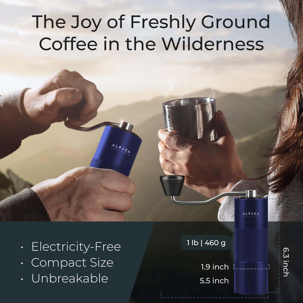 Portable hand-crank coffee grinder being used at a forest campsite for fresh brewing