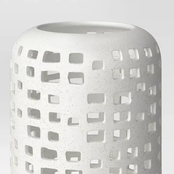 7" modern ceramic candle holder featuring geometric cut-outs and speckled finish, perfect for pillar candles.