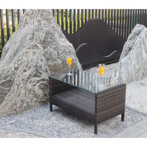 35-inch rectangular coffee table made of weather-resistant brown PE rattan with a tempered glass top in an outdoor setting.