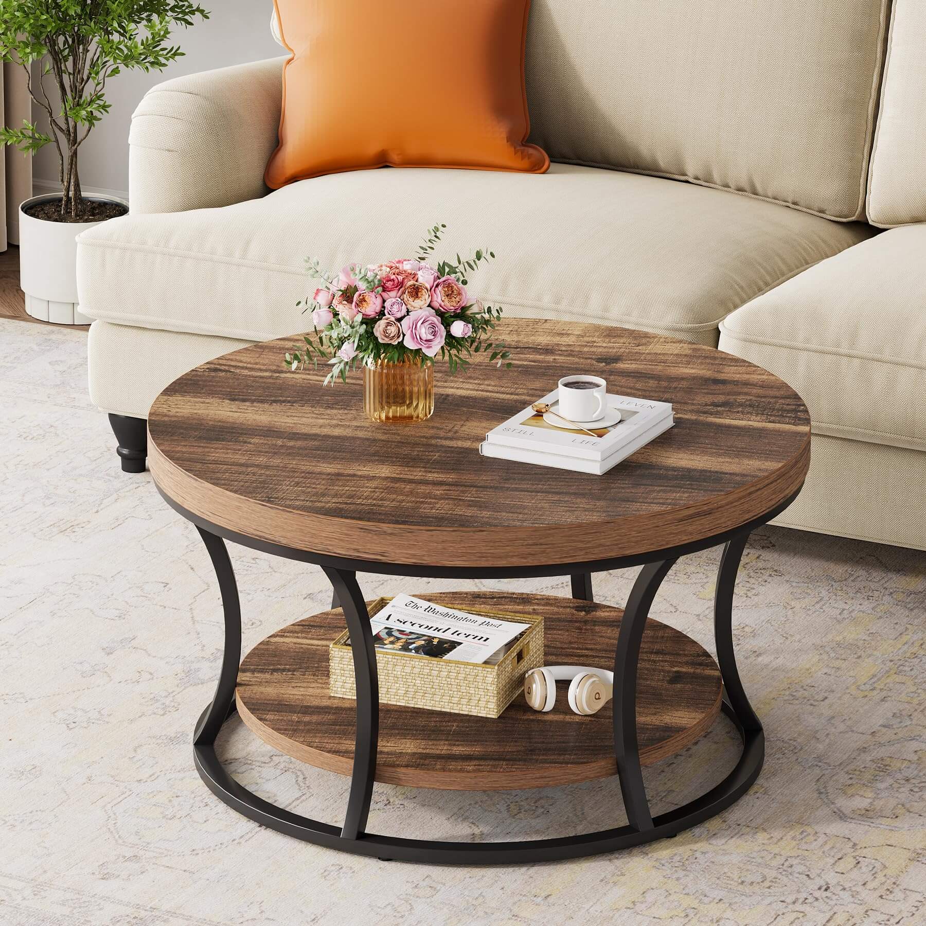 Rustic brown round coffee table styled with books and a candle in a modern cozy living room