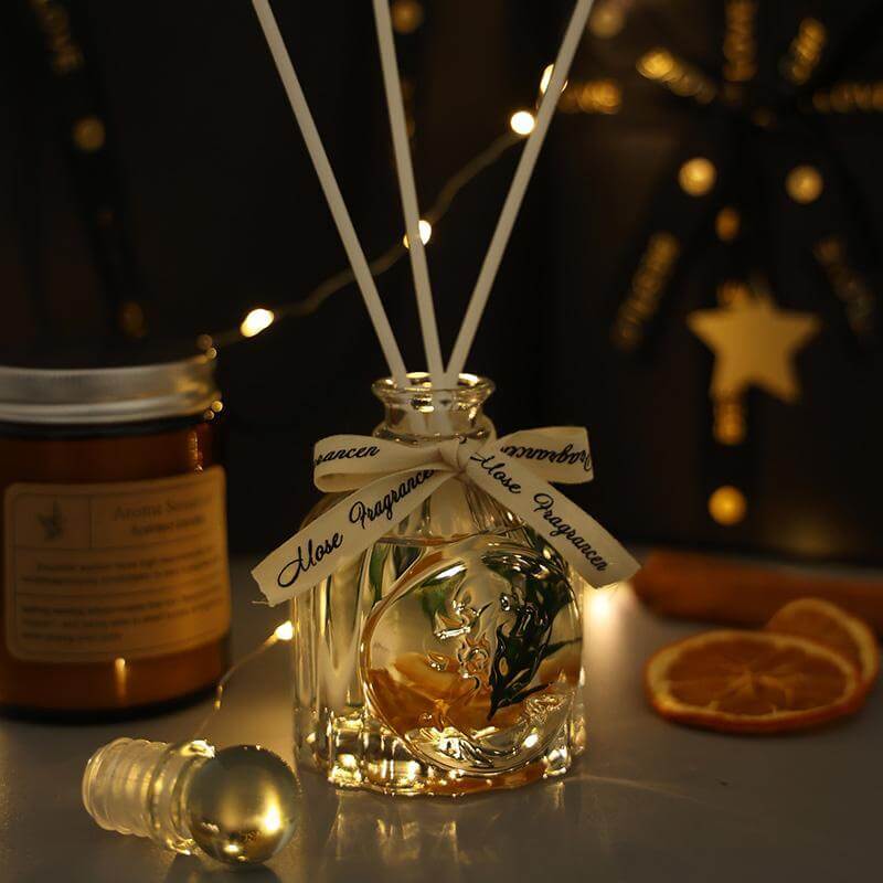 Luxury aromatherapy diffuser with decorative ribbon and surrounding candle, perfect for relaxation and gifting.