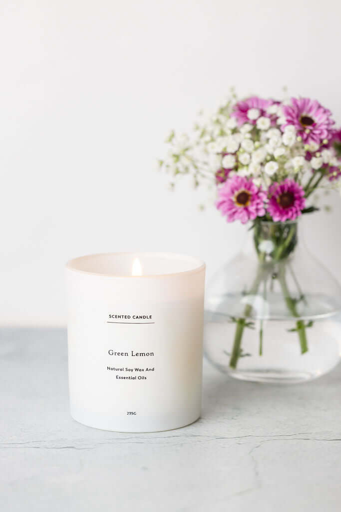 Green Lemon scented candle lit on a coffee table, creating a tranquil atmosphere in a modern living room
