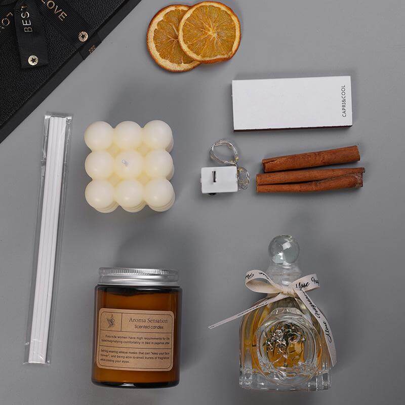 Luxury aromatherapy candle and oil gift set with cinnamon sticks, dried oranges, and wax melts.