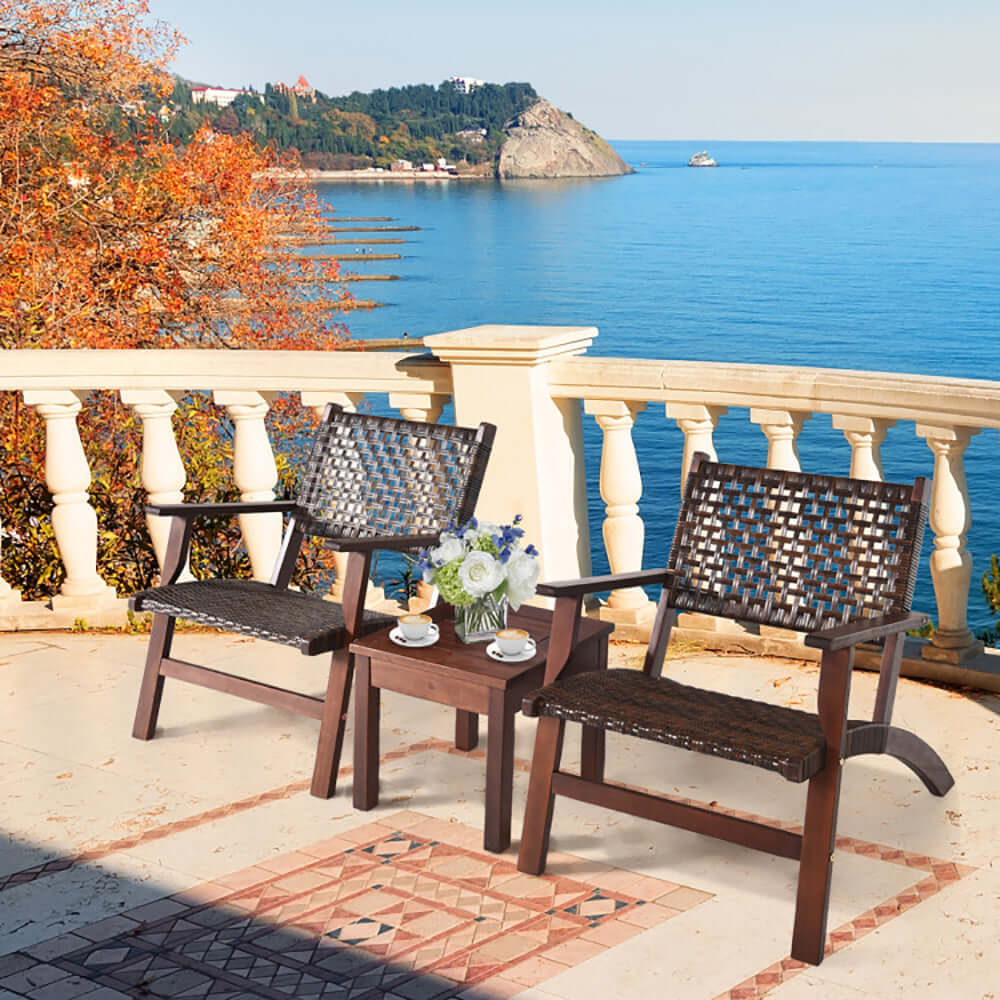 3-piece solid eucalyptus wood and rattan patio set on a balcony overlooking the ocean, perfect for outdoor relaxation.