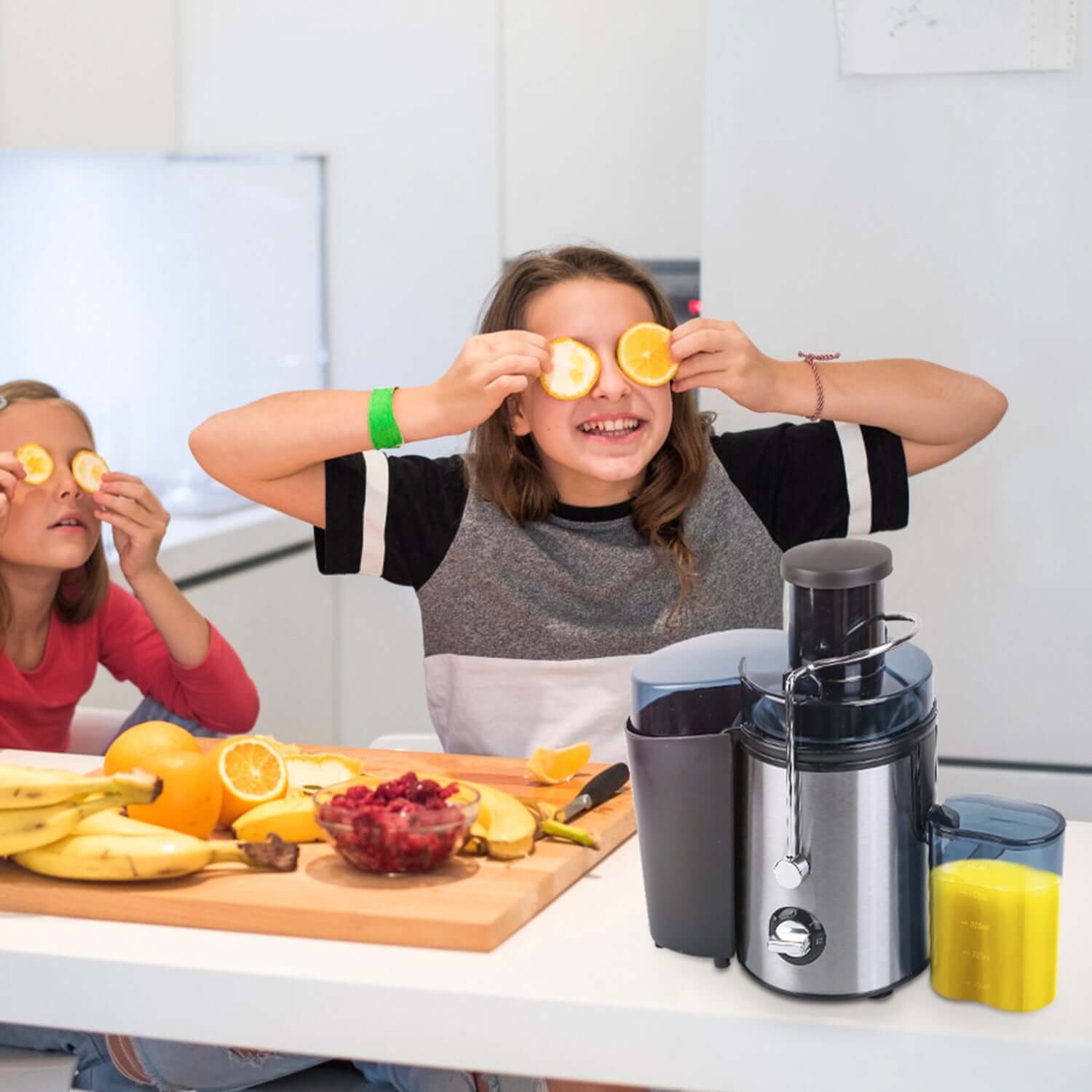 Two kids having fun in the kitchen with a powerful 1000W centrifugal juicer and fresh fruits for juicing.