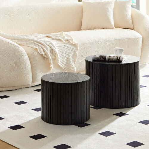 Minimalist living room interior featuring the sleek black nesting tables as a central designer centerpiece.