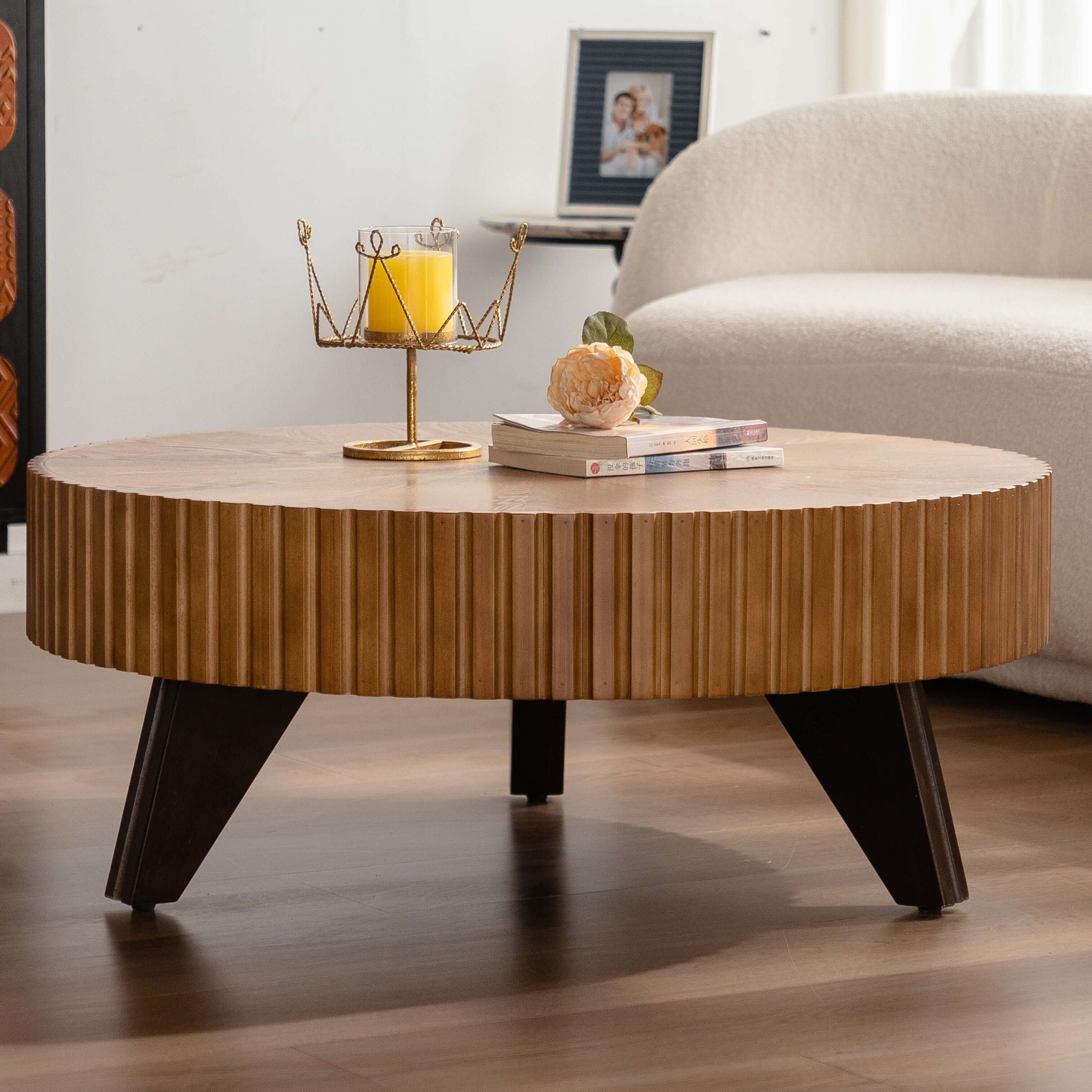 35.4" round retro coffee table with ribbed design and dark wood legs, styled with a candle and books on a modern living room floor.